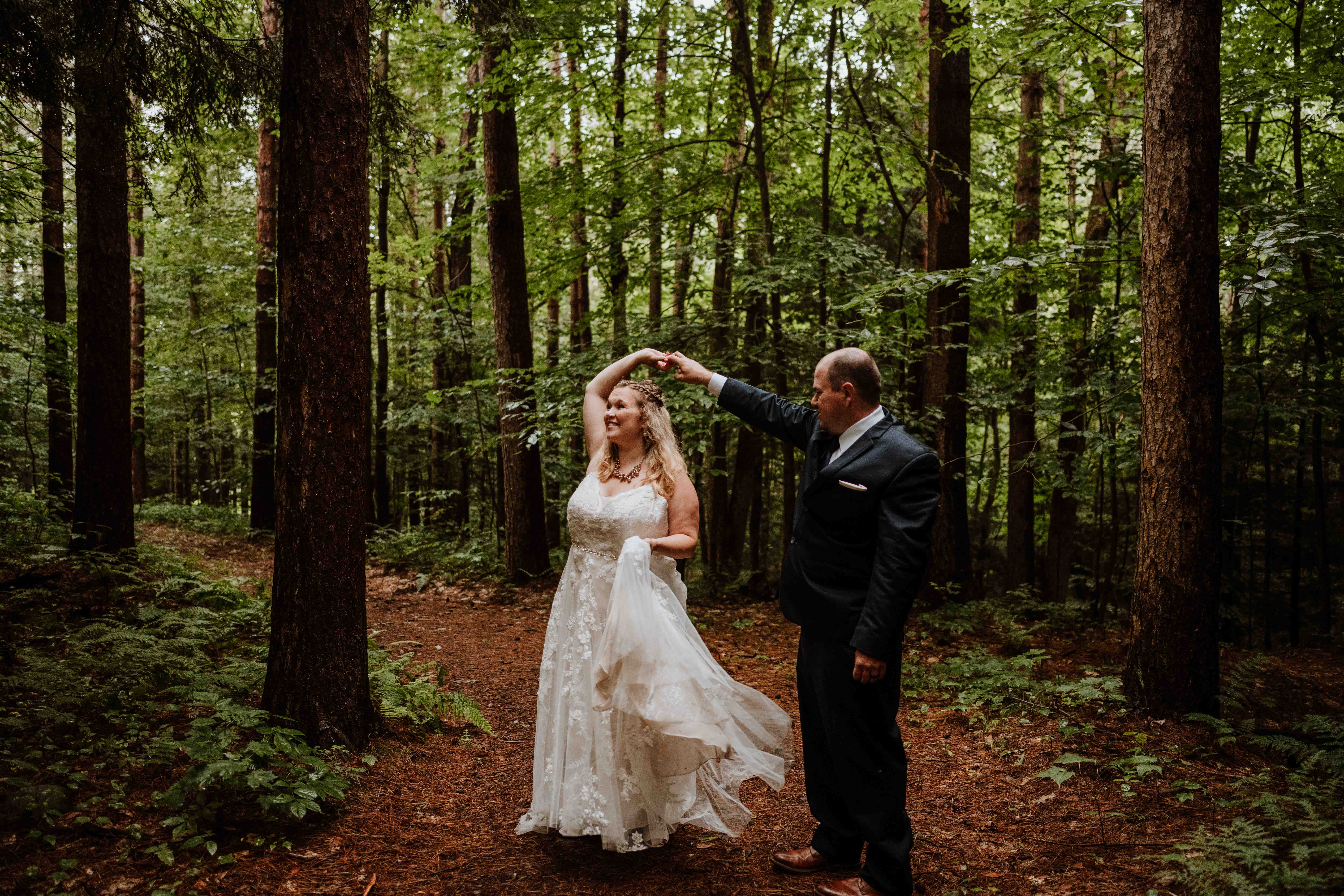 Newly eloped couple dancing in the forest together