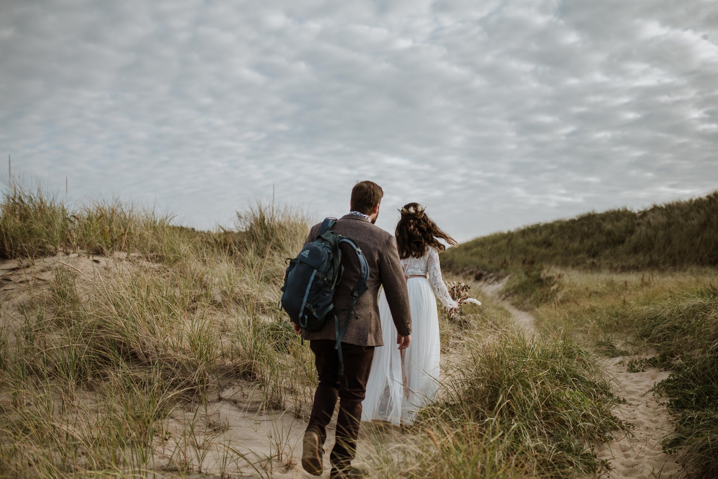 A couple adventuring around dunes for their "just us" elopement experience. 