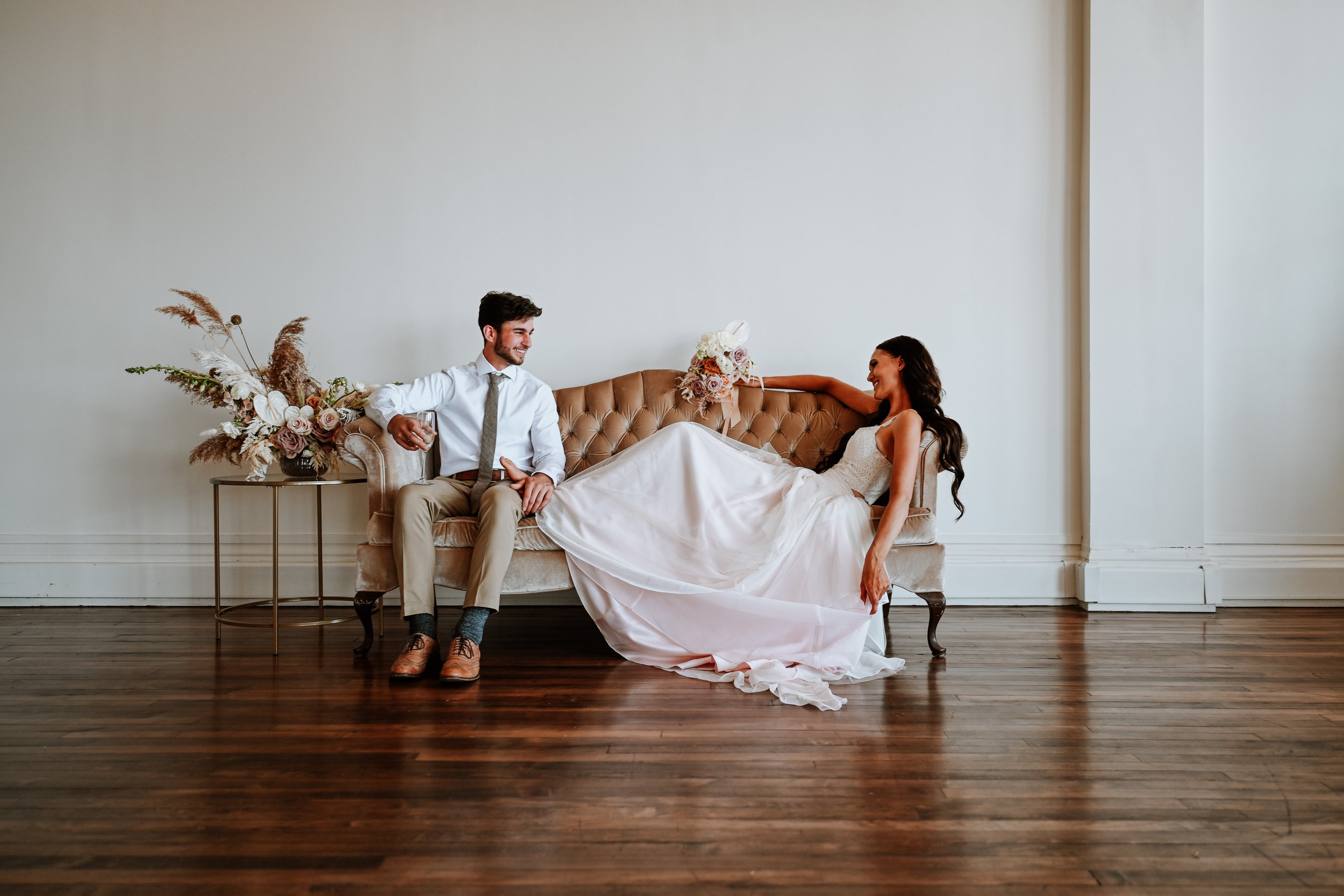 Couple sitting together on a couch for some time alone at their wedding.