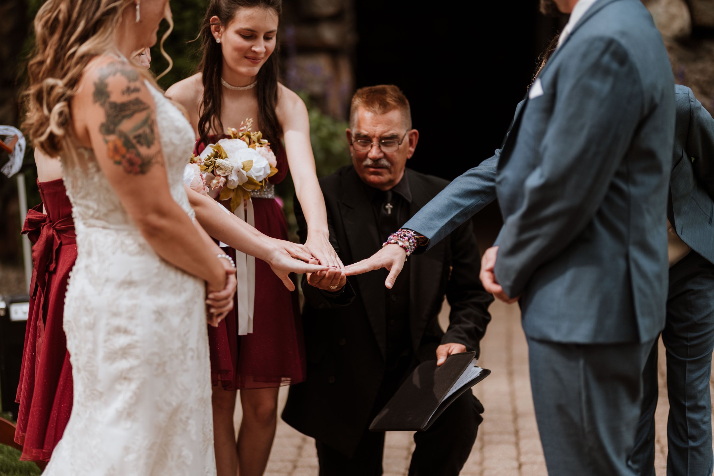 A ring warming at an intimate wedding ceremony where the children of the couple are all touching the newlywed couple's rings.