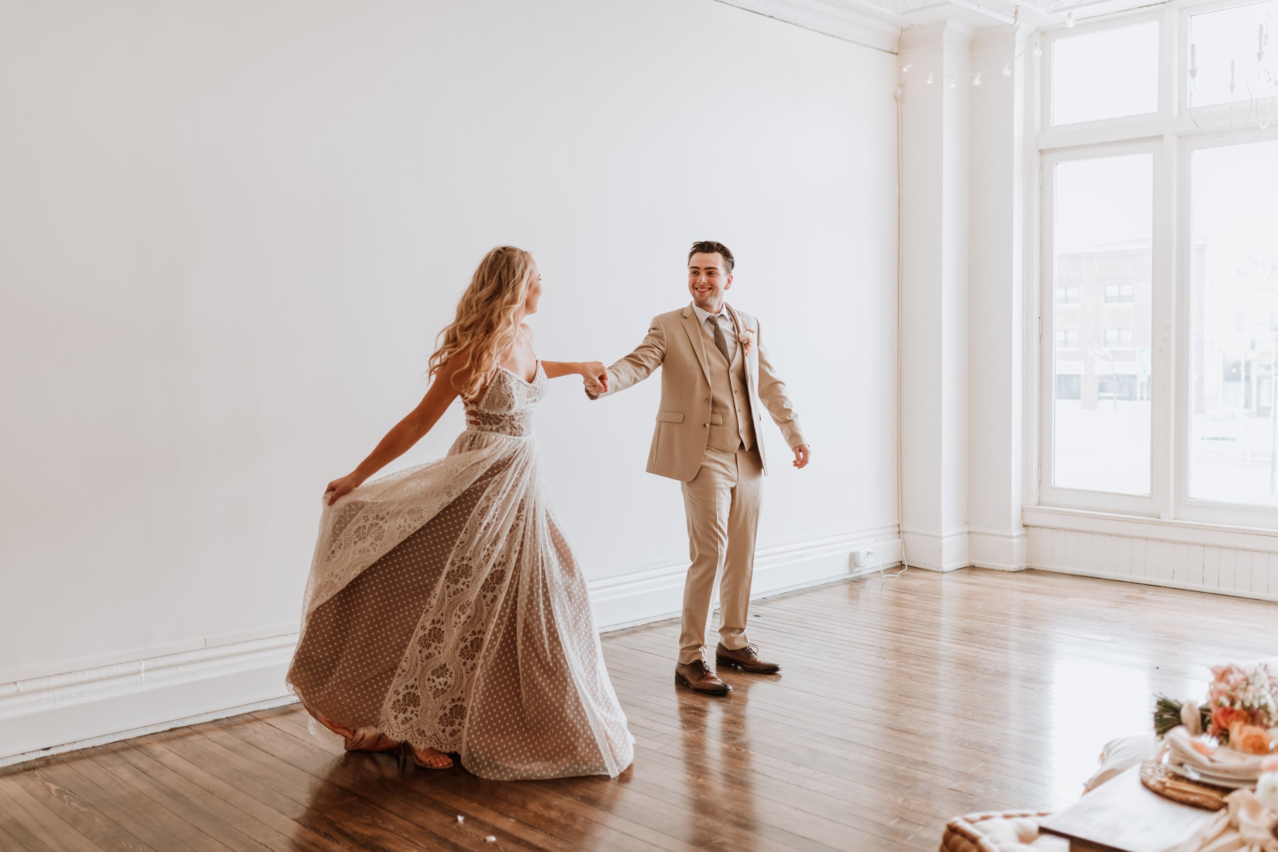 Newlywed couple dancing together in an empty room